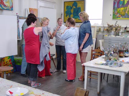 aantrekken van verfschorten tijdens de workshop schilderen van een tegeltableau